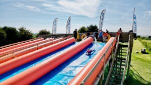 Child sliding down the giant inflatable slide at Cornwall Slip and Slide, Atlantic Reach Resort near Newquay