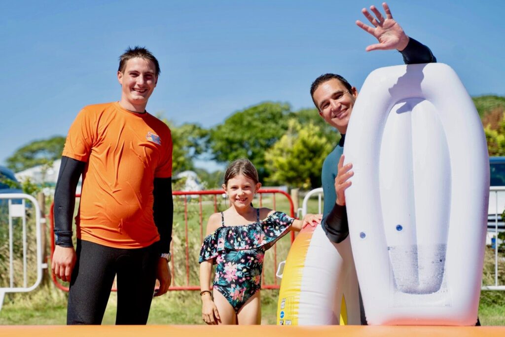 Staff Member Helping Father and Daughter on Giant Inflatable Slide at Cornwall Slip and Slide