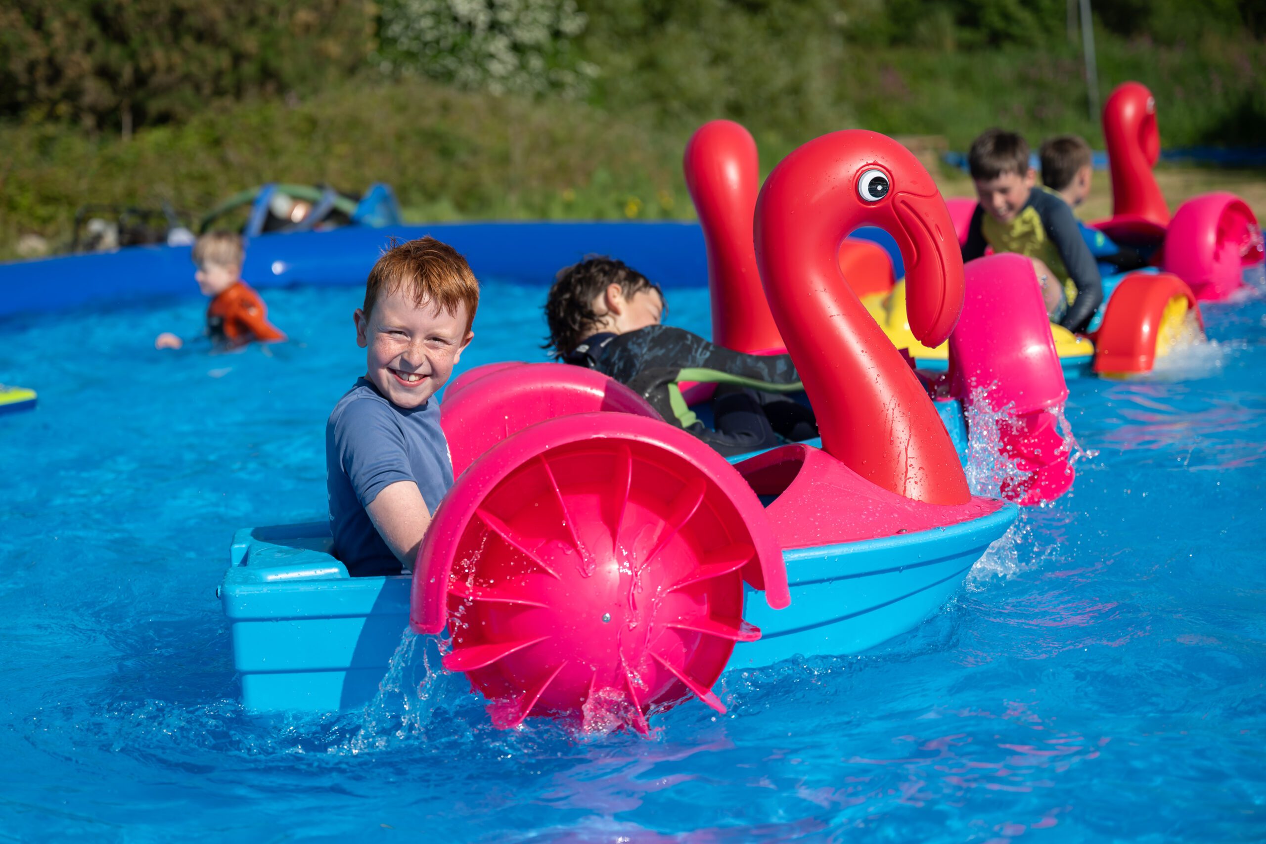 Kids enjoying flamingo pedalos at Cornwall Slip and Slide, Atlantic Reach Resort near Newquay